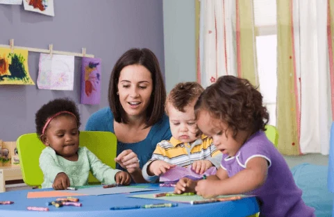Stock photograph of an adult and three children doing crafts indoors. Not a picture of this project.